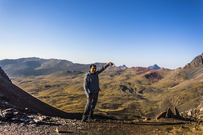 tourist pointing Vinicunca Rainbow mountain